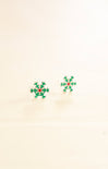 Pair of green snowflake earrings on a beige background