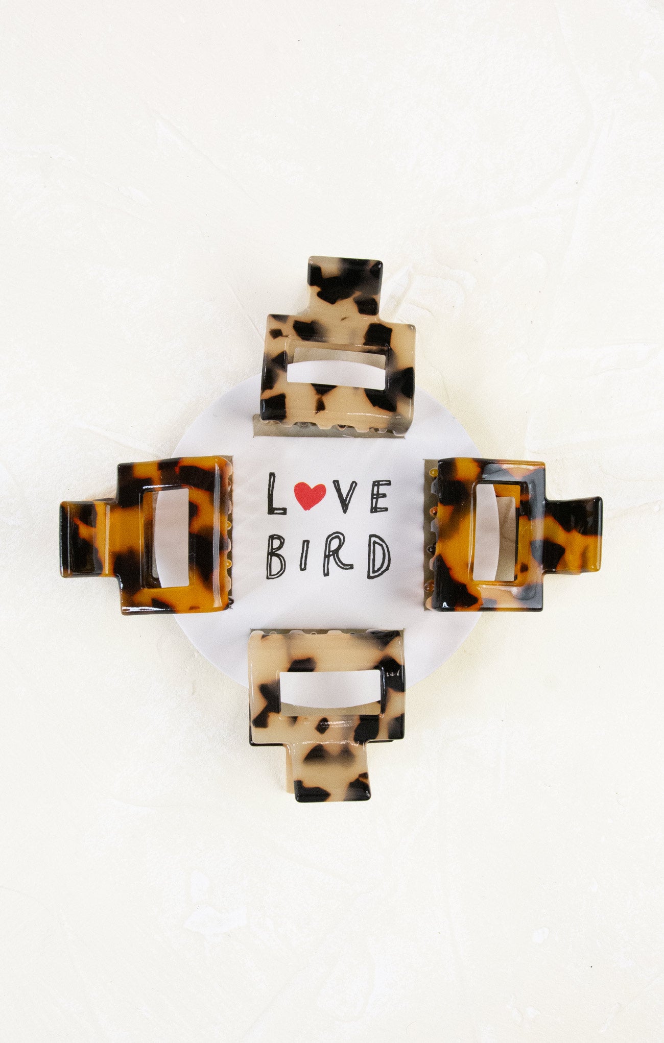 Tortoiseshell hair clip with 'Love Bird' text on a white background