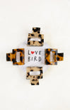 Tortoiseshell hair clip with 'Love Bird' text on a white background