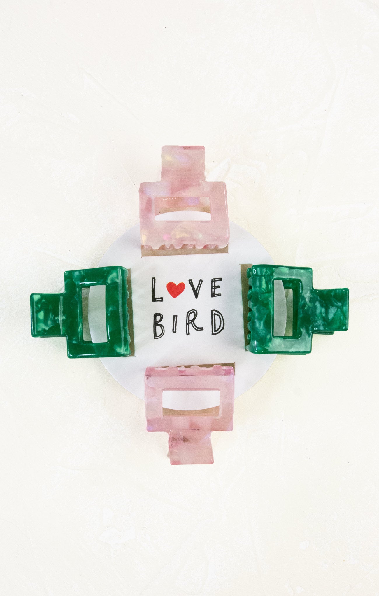 Set of colorful hair clips with 'Love Bird' text on a white background