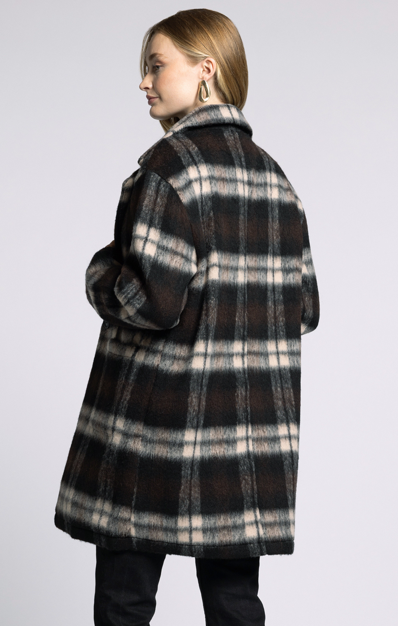 Person wearing a plaid coat on a plain background