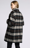 Person wearing a plaid coat on a plain background