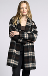 Woman wearing a plaid coat on a plain background