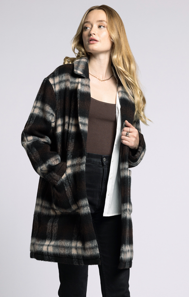 Woman wearing a plaid coat on a plain background