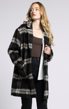 Woman wearing a plaid coat on a plain background