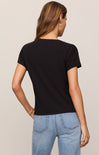 Person wearing a black t-shirt and blue jeans on a beige background