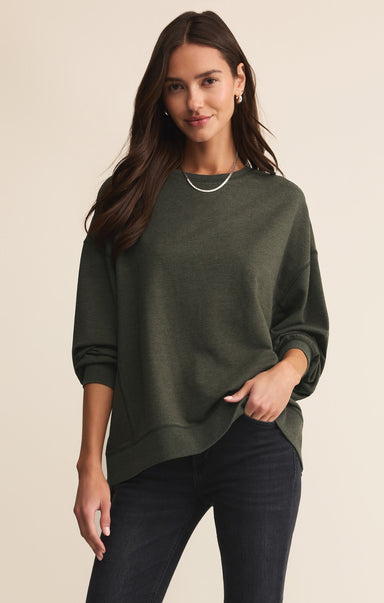 Woman wearing a green sweater against a beige background