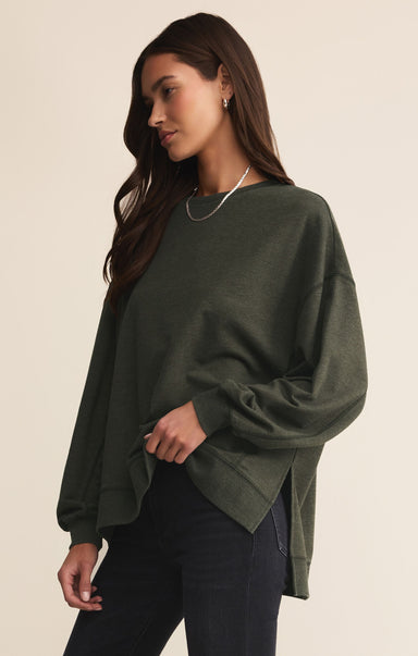 Woman wearing a green sweater against a beige background