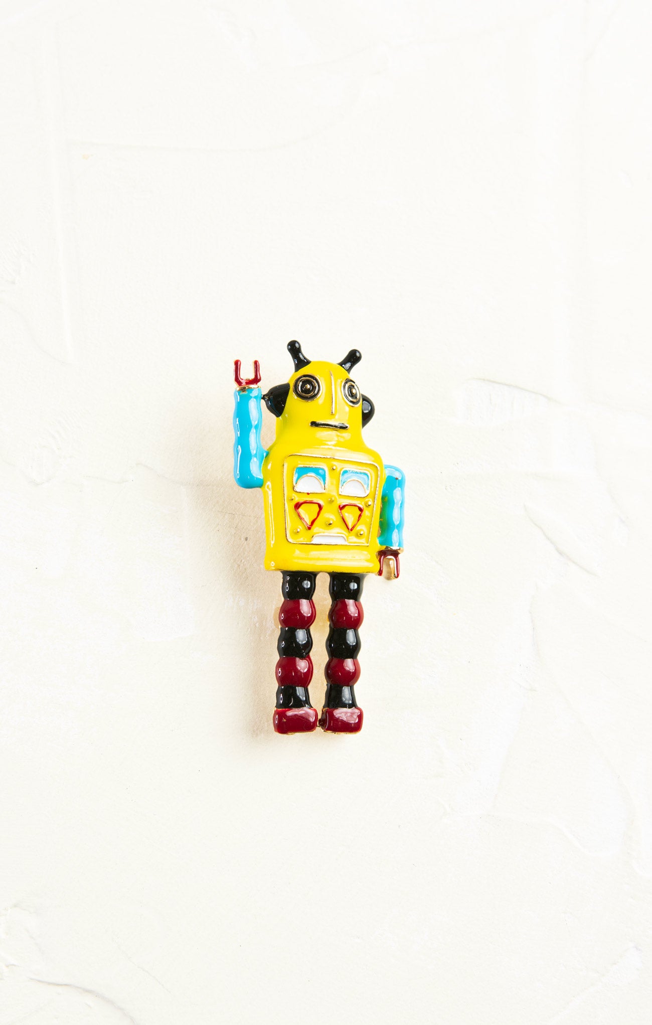 Toy robot with a yellow body and red legs on a white background