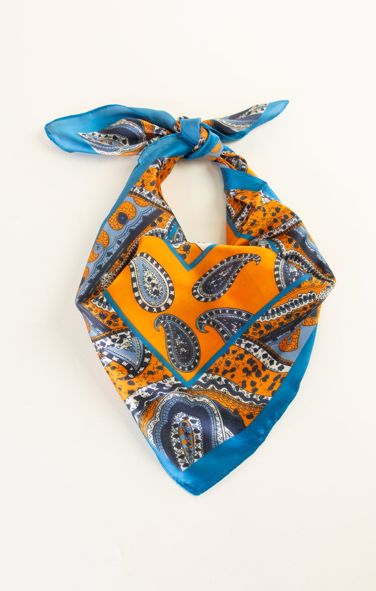 Paisley patterned bandana with orange and blue colors on a white background
