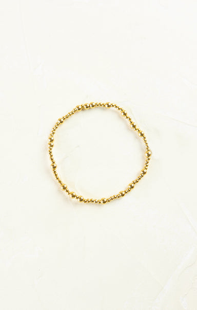 Gold beaded bracelet on a white background