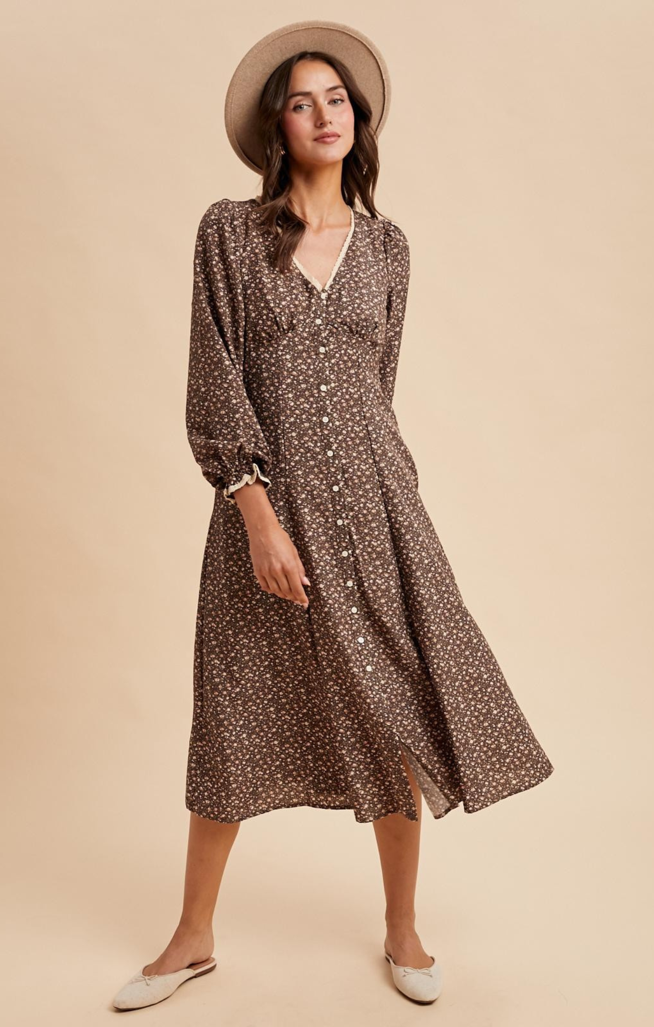 Woman wearing a brown floral dress and hat on a beige background