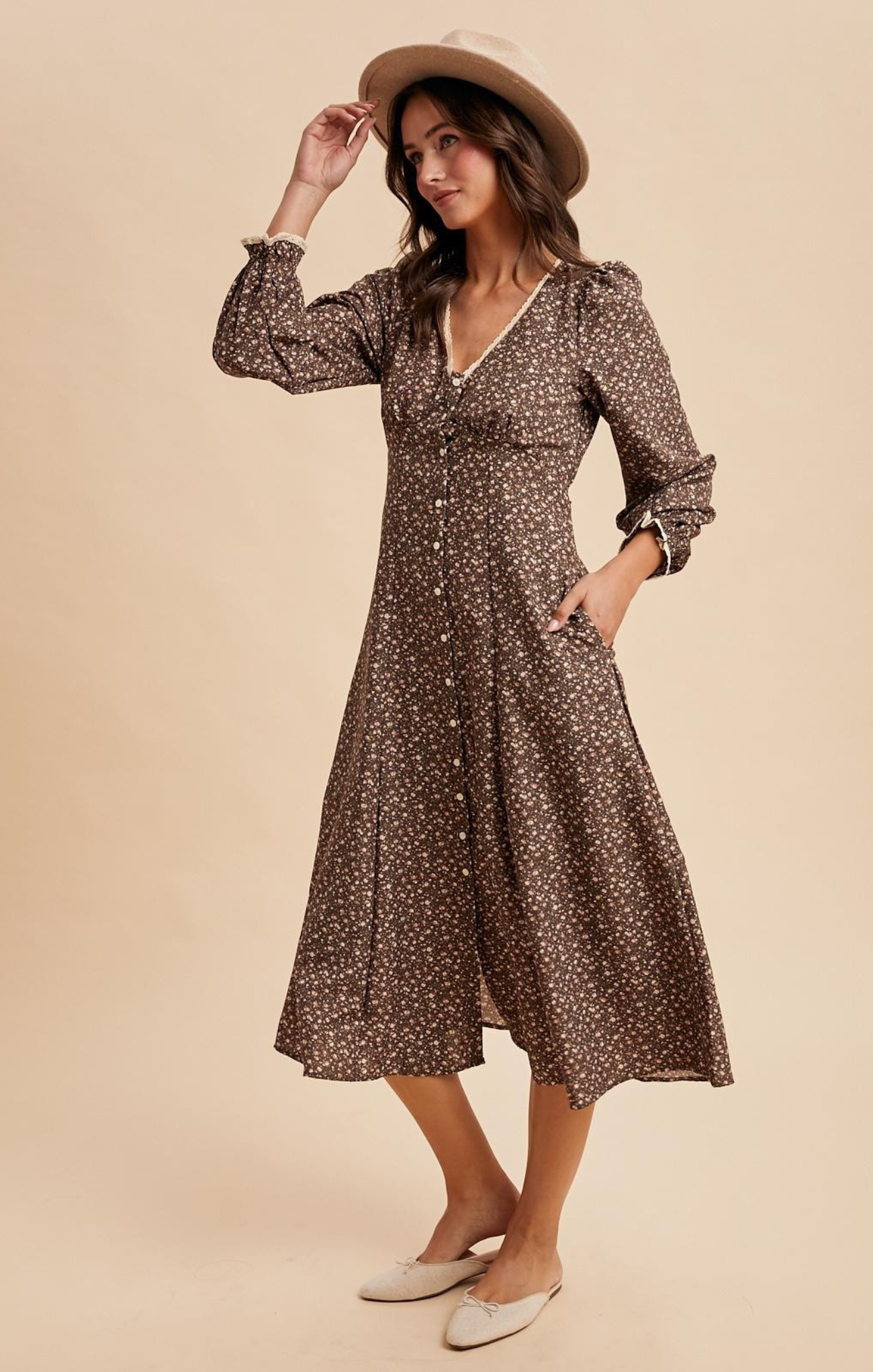 Woman wearing a brown floral dress and hat on a beige background