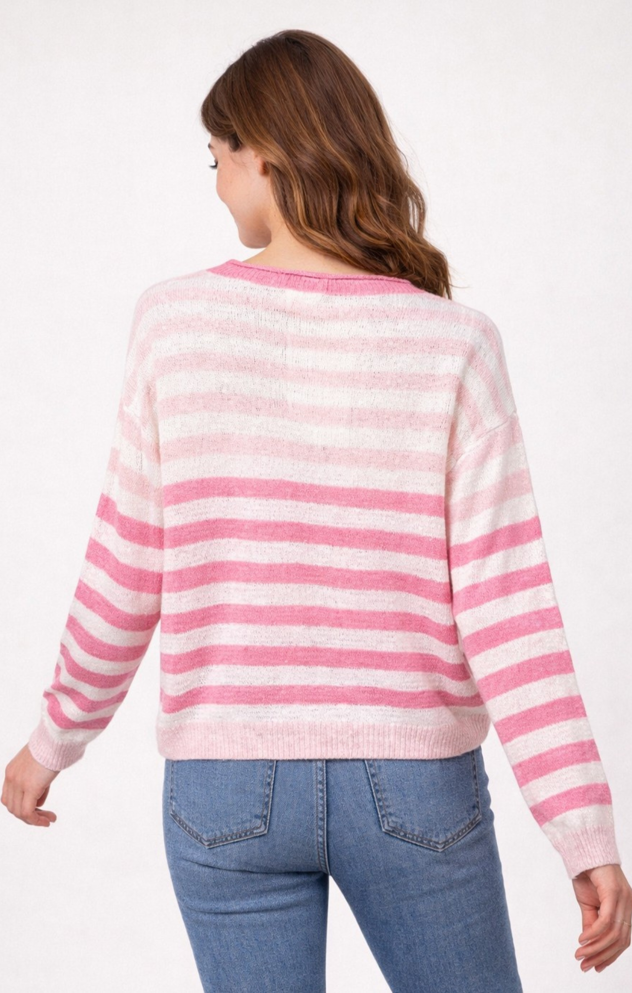 Person wearing a pink and white striped sweater and blue jeans on a white background