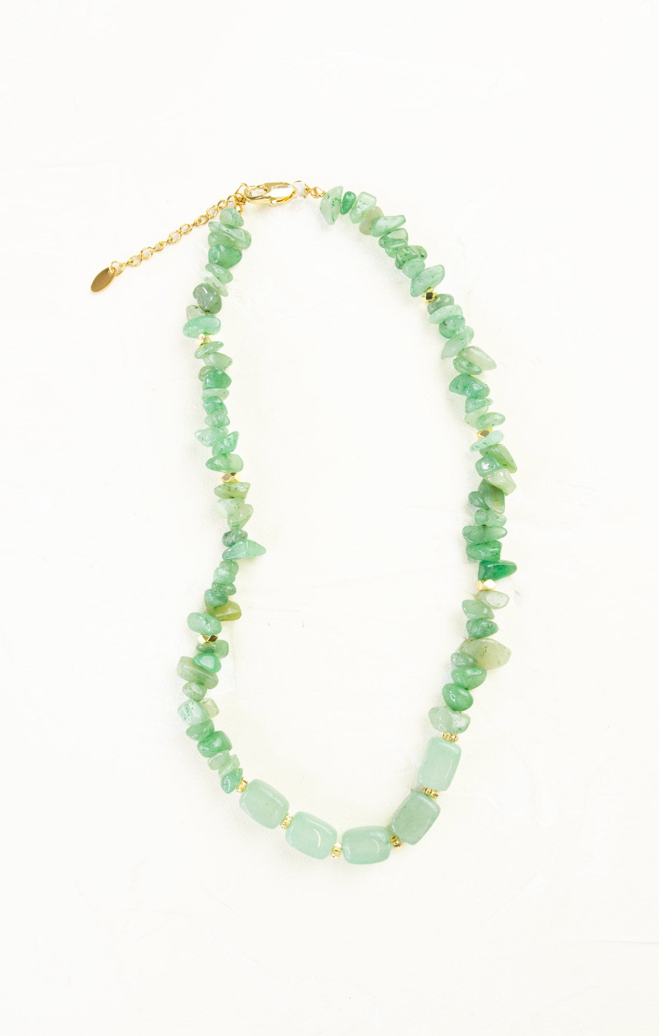 Necklace with green beads and gold accents on a white background