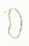 Necklace with green beads and gold accents on a white background