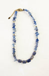 Blue beaded necklace with a gold clasp on a white background