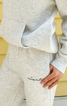 Person wearing a gray tracksuit with 'niantic' branding, standing against a yellow wall.