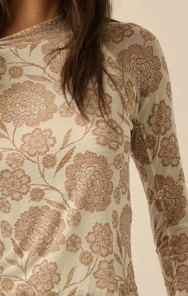 Close-up of a long-sleeve top with a beige and brown floral jacquard pattern, worn by a model.