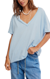 Woman wearing a light blue oversized t-shirt and jeans on a white background