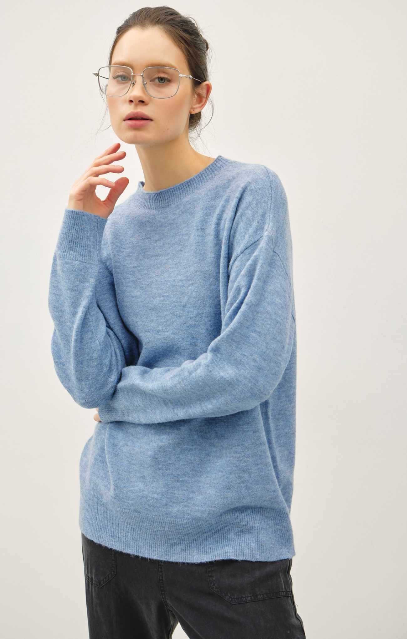 Person wearing a light blue sweater against a plain background