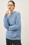 Person wearing a light blue sweater against a plain background
