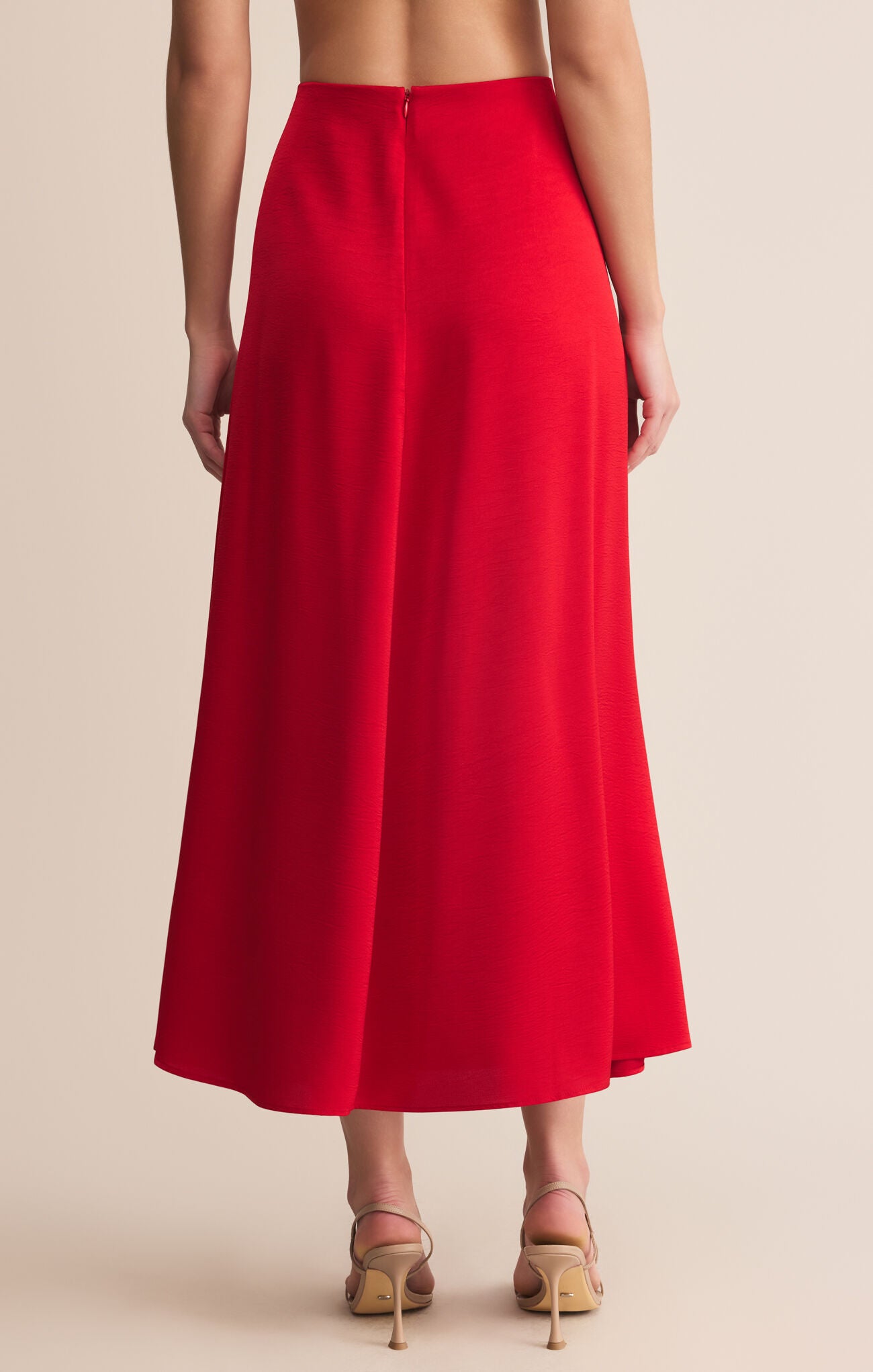 Red skirt worn by a person on a beige background
