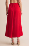 Red skirt worn by a person on a beige background