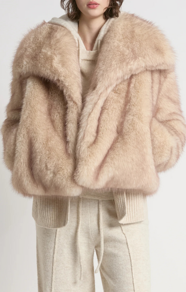 Beige fluffy jacket worn by a person on a white background