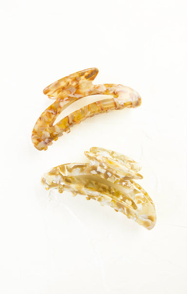 Two gold hair clips with a marble pattern on a white background