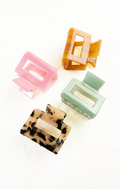 Set of four colorful hair clips on a white background