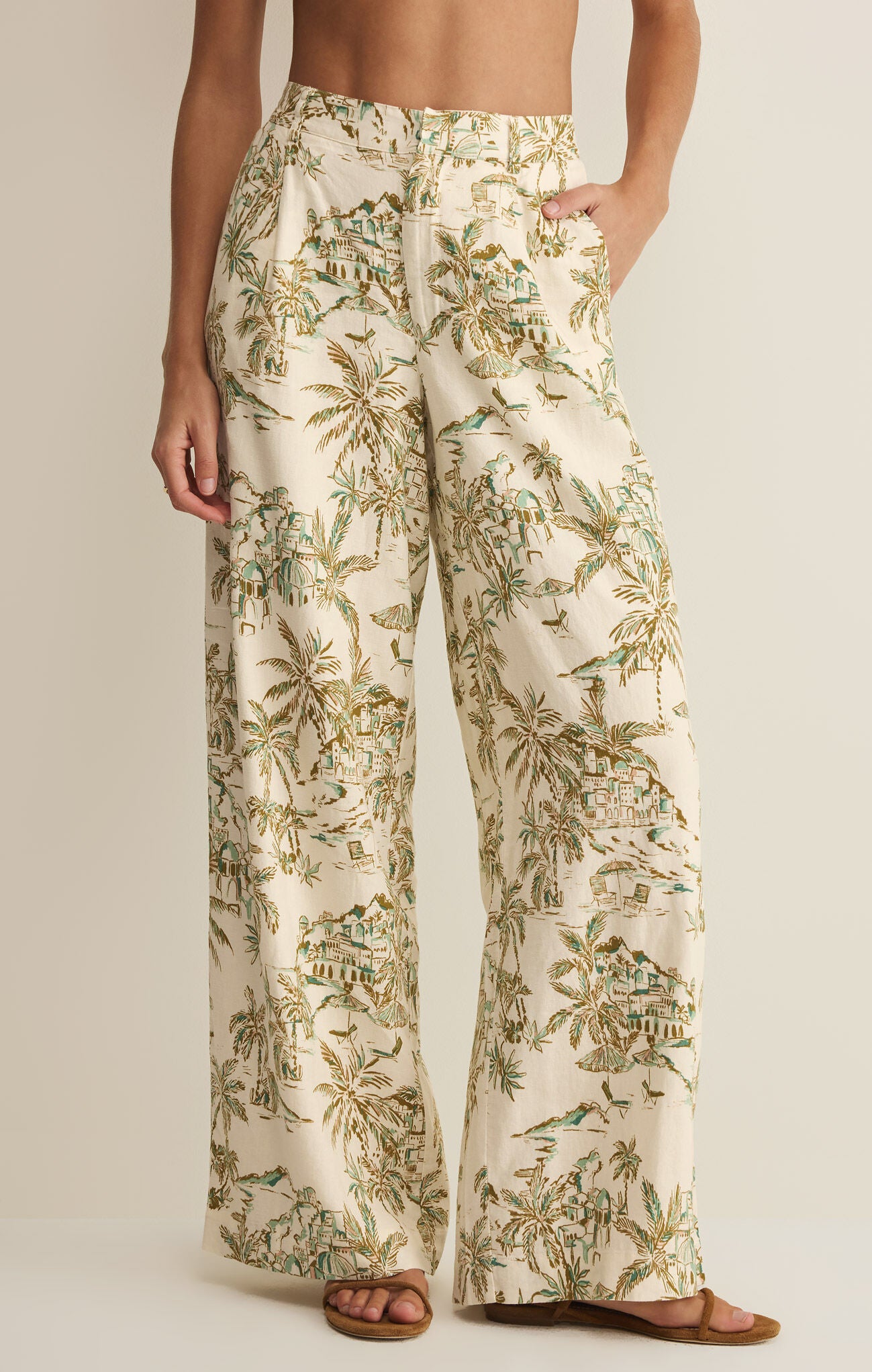 Tropical patterned pants worn by a person on a plain background
