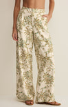 Tropical patterned pants worn by a person on a plain background