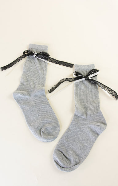Gray socks with black lace bows on a white background