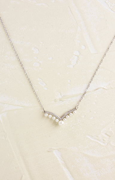 Pearl necklace on a textured beige background
