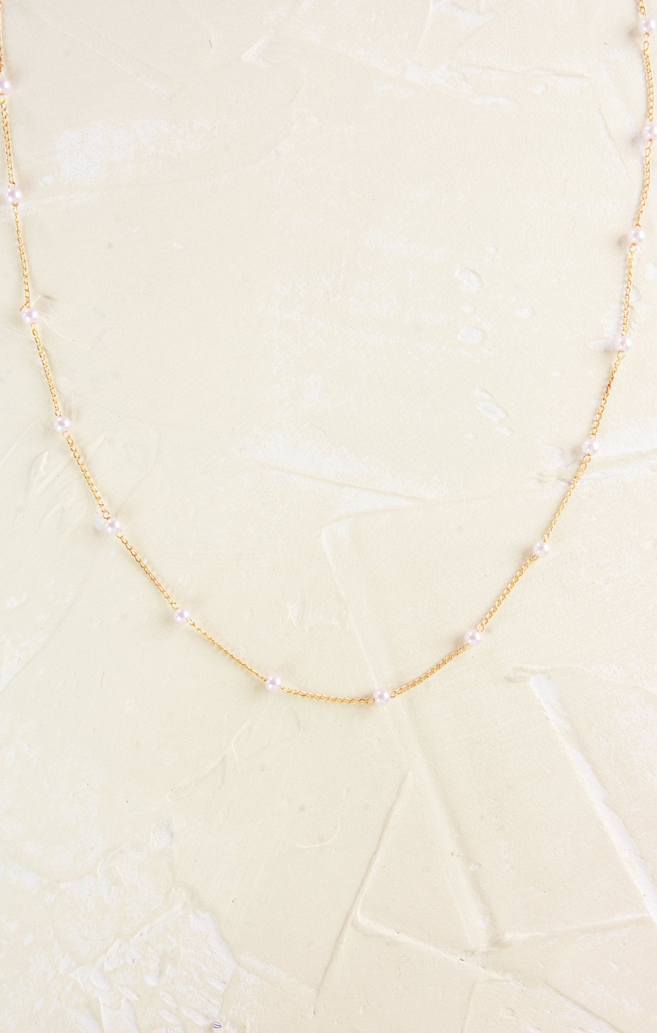 Necklace with pearls on a light beige background