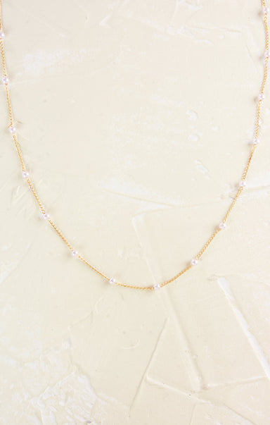 Necklace with pearls on a light beige background