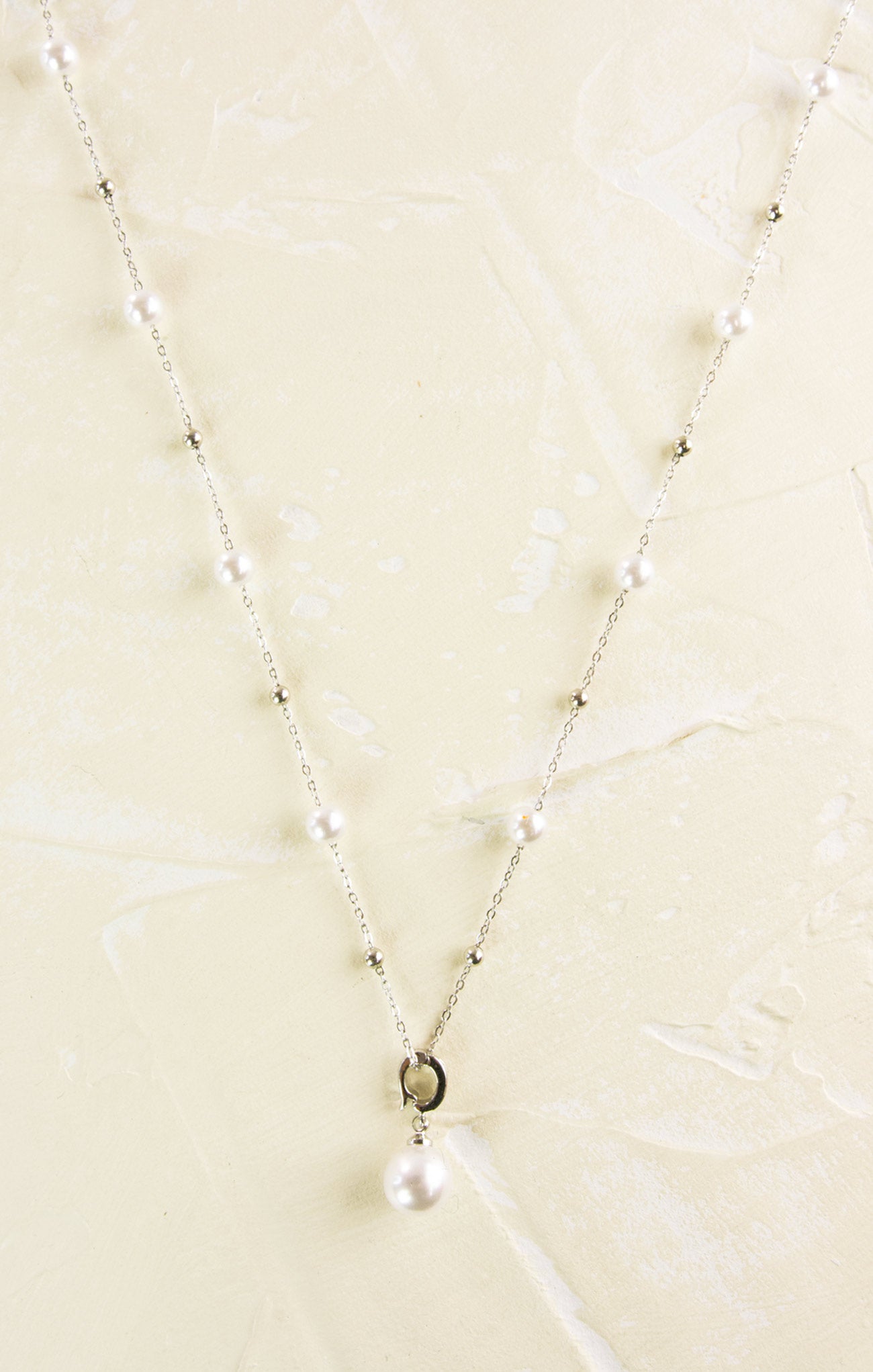 Pearl necklace on a beige textured background