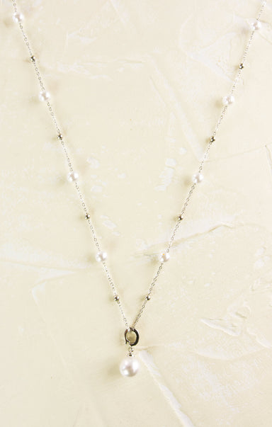 Pearl necklace on a beige textured background