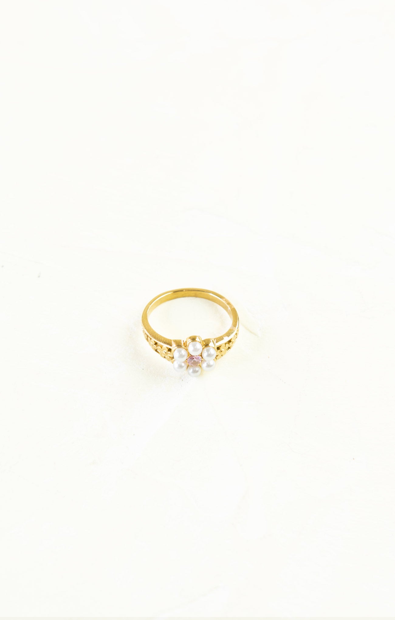 Gold ring with a pearl on a white background