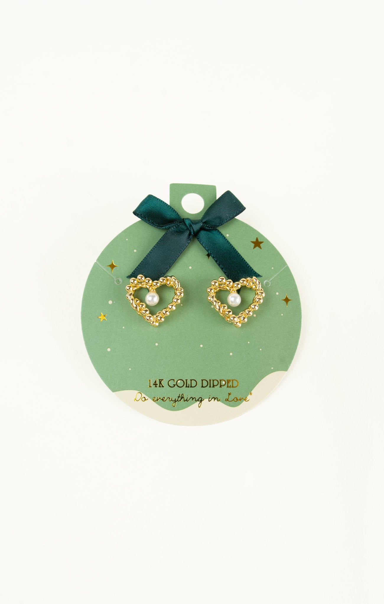 Gold heart-shaped earrings on a green card with a bow