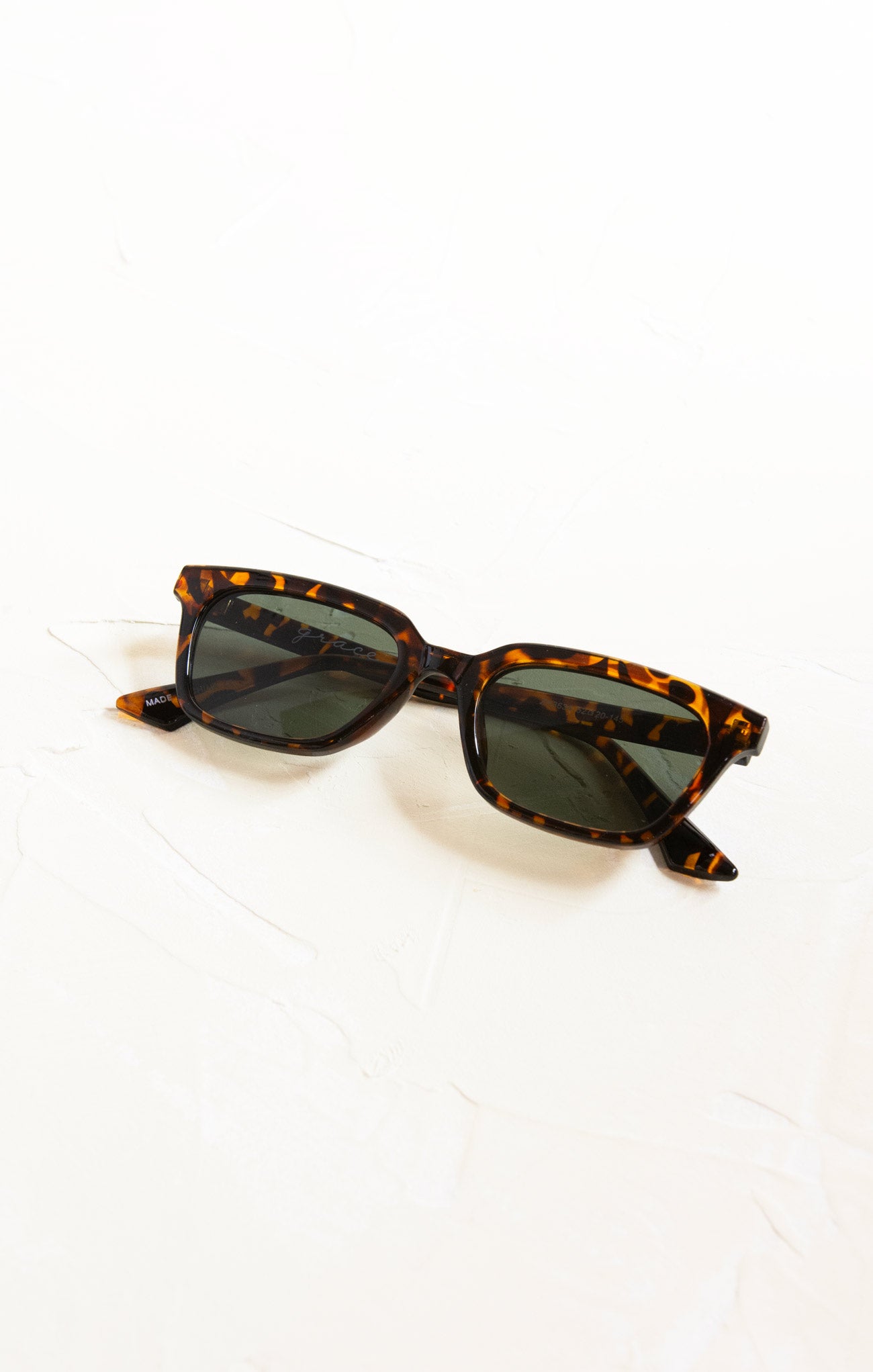 Sunglasses with tortoiseshell frame on a white background