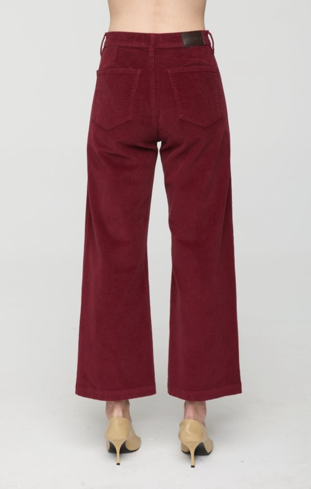 Maroon corduroy pants on a white background