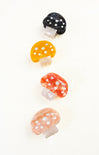 Set of colorful mushroom-shaped hair clips on a white background