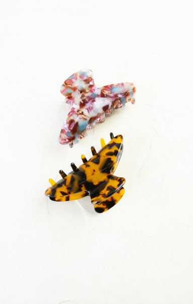 Two hair clips, one floral and one tortoiseshell, on a white background