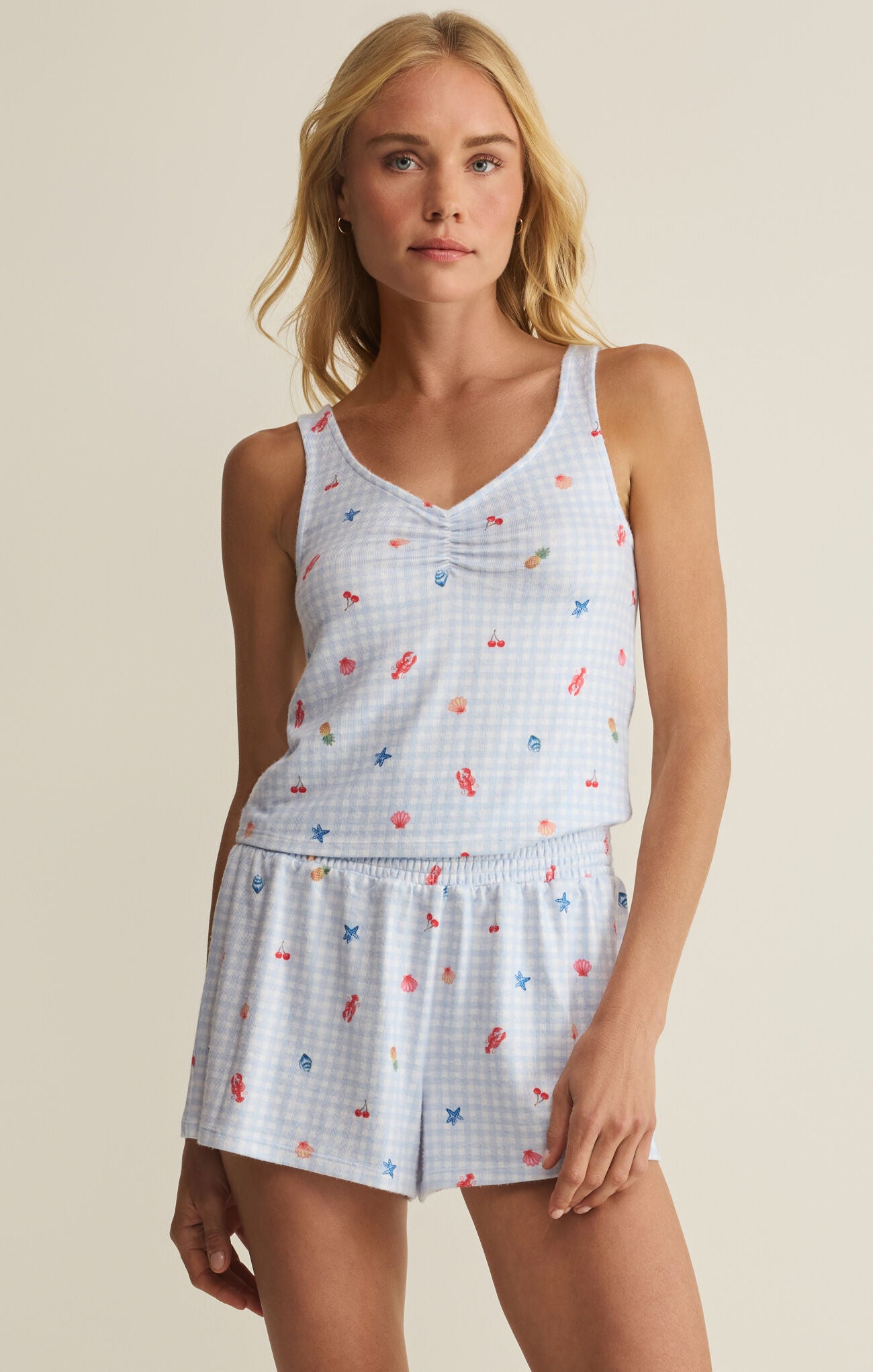 Woman wearing a sleeveless top and shorts with a pattern on a beige background