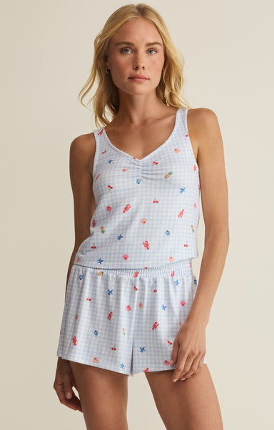 Woman wearing a sleeveless top and shorts with a pattern on a beige background