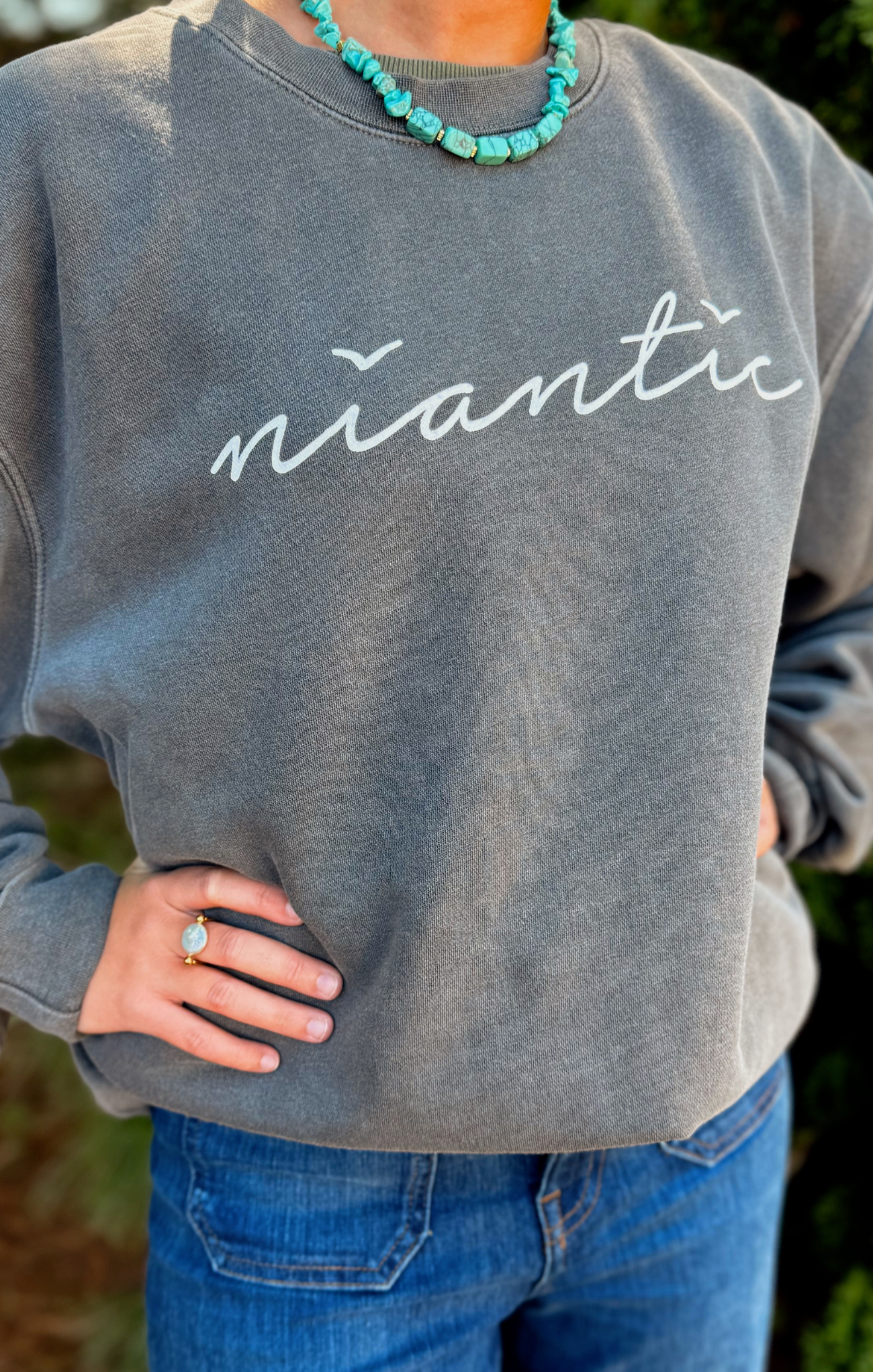 Person wearing a gray sweatshirt with 'niantic' text, standing outdoors.