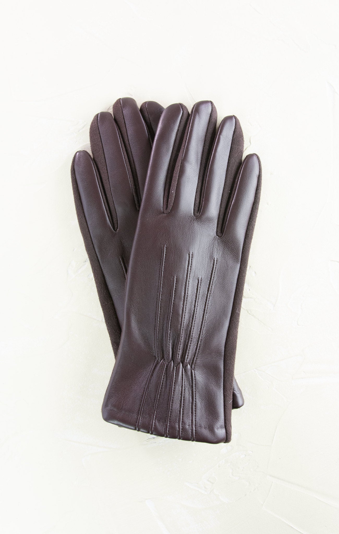 Pair of dark brown leather gloves on a white background