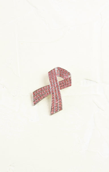 Pink ribbon brooch with crystals on a white background